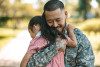 Military father hugging young daughter