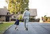 Woman in military fatigues and child walking toward house