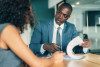 Black businessman reviews a real estate contract with a female client in a modern office