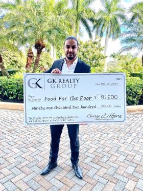 George Khoury holds a large donation check in his hands